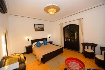 a bedroom with a bed with blue pillows on it at Targafit Hotel & Hammam in Marrakech