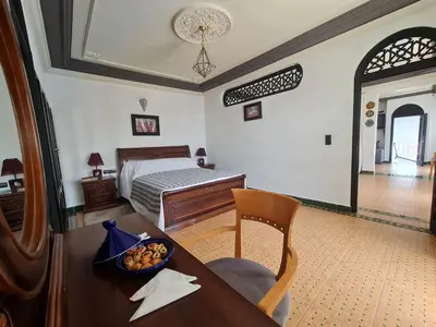 a bedroom with a bed and a table with a bowl of fruit on it at Targafit Hotel & Hammam in Marrakech