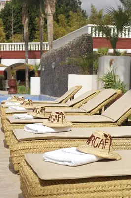 a row of straw chairs with napkins on them at Targafit Hotel & Hammam in Marrakech