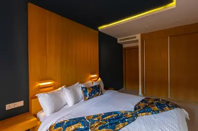a bedroom with a large bed with a wooden headboard at AppartHotel Atrani in Marrakech