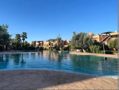 a swimming pool in a resort with palm trees and houses at Atlas golf in Marrakech