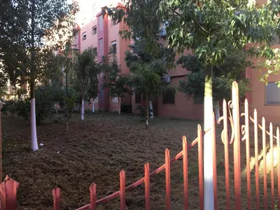 a wooden fence in front of a pink building at Firdaouss apartment in Marrakech