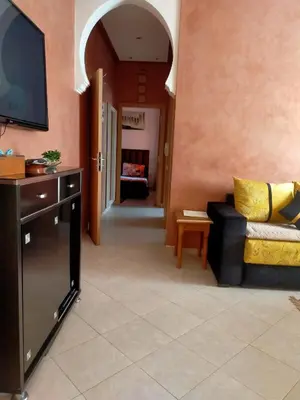 a living room with a couch and a flat screen tv at Firdaouss apartment in Marrakech
