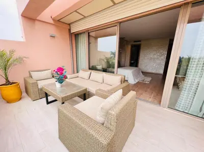 a patio with wicker chairs and a couch and a table at Villa golf prestigia marrakech in Marrakech