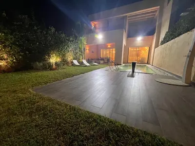 a house with a patio at night at Villa golf prestigia marrakech in Marrakech