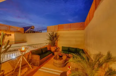 a balcony with couches and plants on a building at riad paradis blanc in Marrakech
