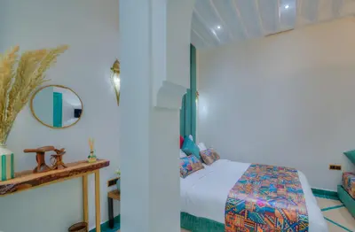 a bedroom with a bed and a mirror at riad paradis blanc in Marrakech