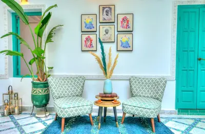 two chairs and a table in a room with blue doors at riad paradis blanc in Marrakech
