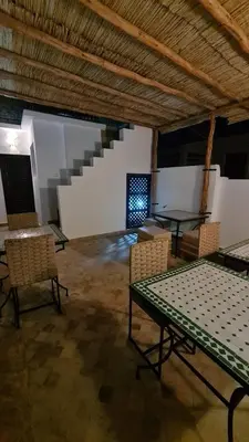 a room with a table and chairs and stairs at Riad Alizé in Marrakech