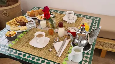 a table with breakfast foods and coffee on it at Riad Alizé in Marrakech