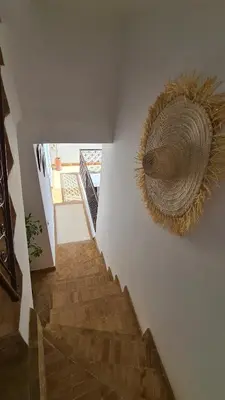 a staircase with a straw hat on a wall at Riad Alizé in Marrakech