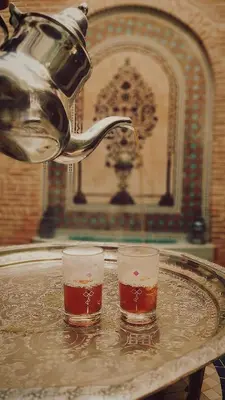 two glasses of beer on a table with a tea kettle at Riad Bonheur in Marrakech
