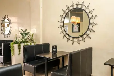 a dining room with a table and chairs and a mirror at Hotel Majorelle in Marrakech