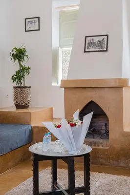 a coffee table in a living room with a fireplace at Hôtel Dar 55 - Berber House - Boutique Hôtel in Marrakech