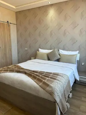 a bedroom with a large bed with white sheets at Riad L'Aéroport in Marrakech