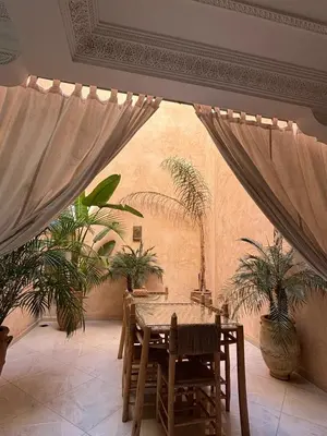 a dining room with a table and potted plants at Riad L'Aéroport in Marrakech