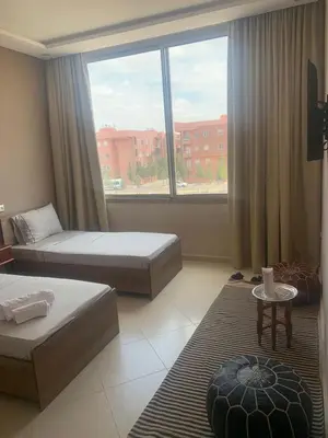 a bedroom with two beds and a large window at Riad L'Aéroport in Marrakech
