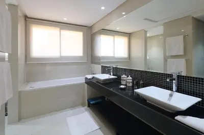 a bathroom with two sinks and a bath tub and a mirror at Villa Firdaous in Marrakech