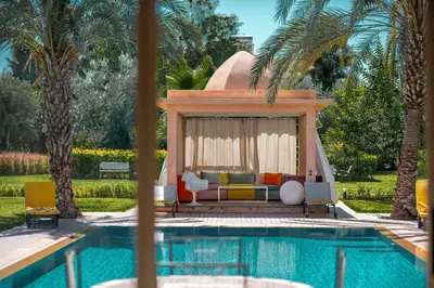 a villa with a swimming pool and a villa with palm trees at Villa Cartier in Marrakech