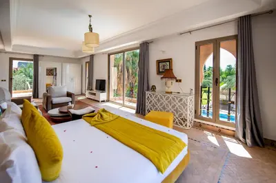 a bedroom with a large bed and a living room at Villa Cartier in Marrakech