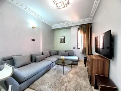 a living room with a couch and a tv at Central Aparts Av Prince Moulay Abdellah in Marrakech