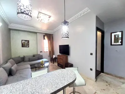 a living room with a couch and a tv at Central Aparts Av Prince Moulay Abdellah in Marrakech