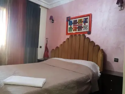 a bed with a wooden headboard in a bedroom at Central Aparts Av Prince Moulay Abdellah in Marrakech