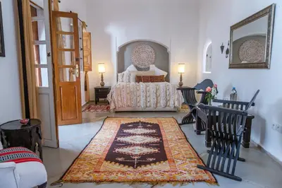 a bedroom with a bed and a large rug at Riad Dar Talah in Marrakech