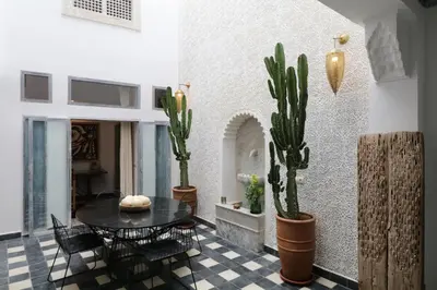 a dining room with a table and cactus at Riad-Shakho-Marrakech in Marrakech