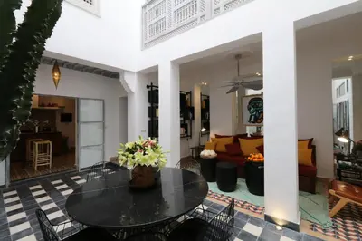 a dining room and living room with a table and chairs at Riad-Shakho-Marrakech in Marrakech