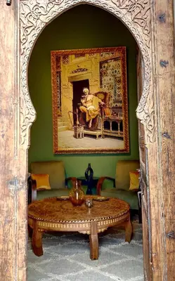 a living room with a table and a painting on the wall at Riad Dar Chacha in Marrakech