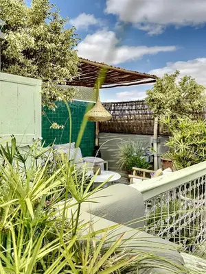 a patio with tables and chairs in a garden at Riad Dar Chacha in Marrakech