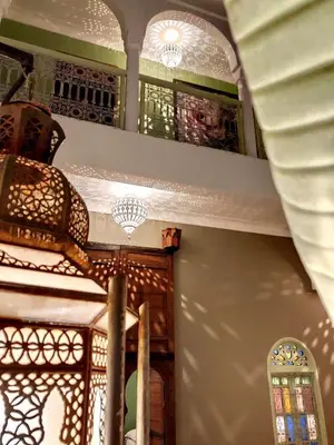 a room with a chandelier and stained glass windows at Riad Dar Chacha in Marrakech