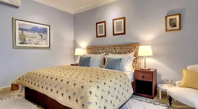 a bedroom with a large bed and a chair at Riad Dar Chacha in Marrakech