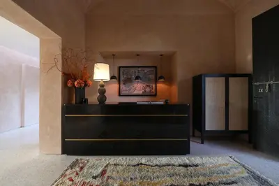 a living room with a black dresser and a lamp at Villa Dar Challa in Marrakech