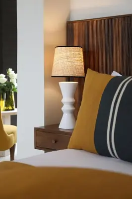 a bed with a yellow pillow and a lamp on a night stand at Villa Dar Challa in Marrakech