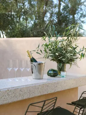 a table with a bottle of wine and three wine glasses at Villa Dar Challa in Marrakech
