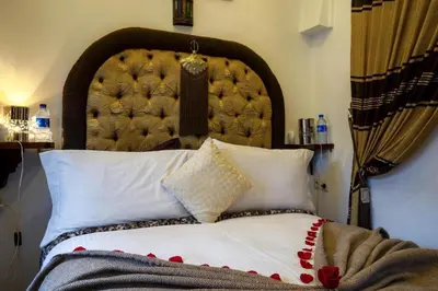 a bed with a large headboard and white pillows at Room in BB - Riad Anabel - Chocolat Double Room in Marrakech