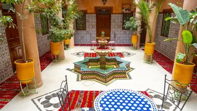 a lobby with a fountain in the middle of a building at Hotel imouzzer in Marrakech