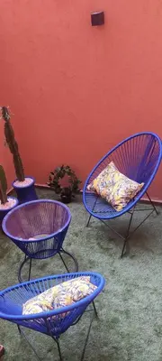 three blue chairs sitting next to a red wall at The Best location to visit Marrakech Carré Eden a little Walk to the Médina in Marrakech