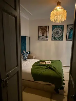 a bedroom with a bed and a chandelier at Riad Dar Chadia in Marrakech