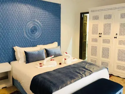 two swans are sitting on a bed in a room at Riad Oscaroi in Marrakech