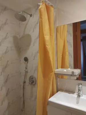 a bathroom with a shower with a yellow shower curtain at marrakech palmeraie village Etablissement jasmin in Marrakech