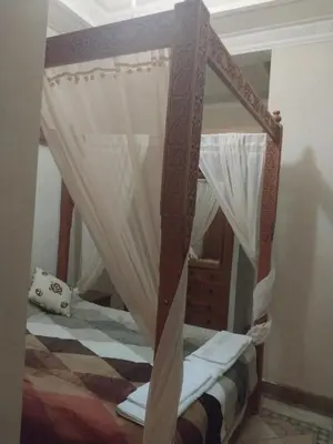 a bedroom with a canopy bed with curtains at marrakech palmeraie village Etablissement jasmin in Marrakech