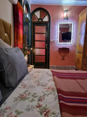 a bedroom with a bed and a mirror and a door at Casa del Sol Marrakech in Marrakech