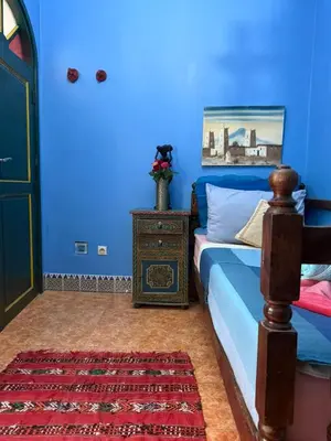 a blue bedroom with a bed and a blue wall at Casa del Sol Marrakech in Marrakech