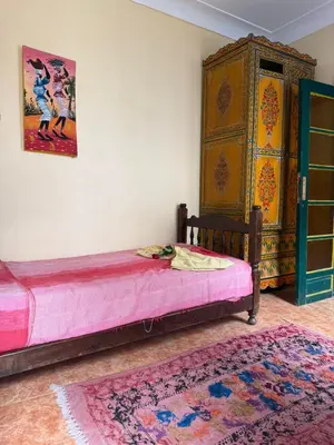 a bedroom with a bed and a painting on the wall at Casa del Sol Marrakech in Marrakech