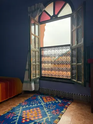 a room with a window and a colorful rug at Casa del Sol Marrakech in Marrakech
