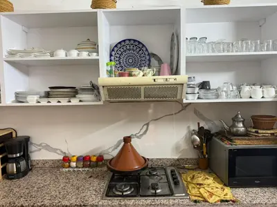 a kitchen counter with a stove and plates and dishes at Casa del Sol Marrakech in Marrakech