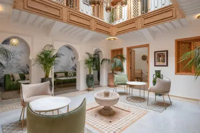 a living room with chairs and tables and a ceiling at Riad Le Saadien ,Adult only in Marrakech